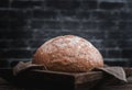 Round white bread in a wooden dish on the table. Royalty Free Stock Photo