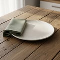 Round white ceramic plate placed on a rustic wooden table, accompanied by a folded Royalty Free Stock Photo