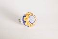 Round white drawer pull or knob with a yellow and blue flower design