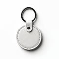 Round white leather keychain with metal ring isolated on plain background. Blank circular tag for keys, simple accessory. Clean Royalty Free Stock Photo