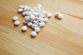 Round white natural vitamin mineral pills lies on wooden table Royalty Free Stock Photo