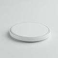 Round white object resembling a minimalist, modern wireless charging pad. The surface Royalty Free Stock Photo
