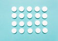 Round, white pills on a blue background. Disease treatment concept, healthcare Royalty Free Stock Photo