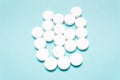 Round, white pills on a blue background Royalty Free Stock Photo