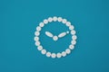 Round white pills clock on blue background Royalty Free Stock Photo