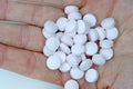 Round white pills in the palm top view. Royalty Free Stock Photo