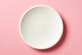 White plate on pink background, from above