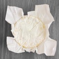 Round of white soft cheese with mould on wax paper Royalty Free Stock Photo