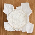 Round of white soft cheese with mould on wax paper Royalty Free Stock Photo