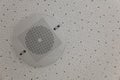 A round white speaker with a mesh is fixed to the white ceiling Royalty Free Stock Photo