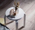 A round white stool with showpiece on wooden floor, bed side corner Royalty Free Stock Photo