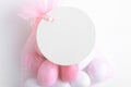 Round white tag mockup with gift with pink chocolate confetti in a bag with pink ribbon. Wedding favor tag for souvenir Royalty Free Stock Photo