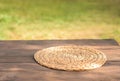 Round wicker napkin for cutlery on a wooden table against the background of autumn nature. Texture table Water Hyacinth Placemat