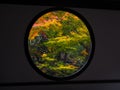 Round Window of Enlightenment with colorful trees in autumn at Genko-an Temple