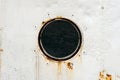 Round window in metallic rusty ship wall