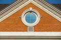 Round window in a red brick wall on the facade of a modern house Royalty Free Stock Photo