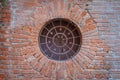 Round window with rusty metal bars on brick wall Royalty Free Stock Photo