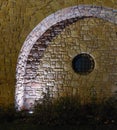 Round window with stone wall arch. Evening lighting Royalty Free Stock Photo