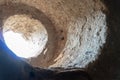 A round window in a thick wall. The Church of the defensive type. A round hole in the wall through which sunlight enters Royalty Free Stock Photo