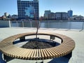 Round wooden bench in the city park on the embankment line