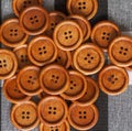 Round wooden brown sewing buttons isolated on textile background. Royalty Free Stock Photo