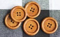 Round wooden brown sewing buttons isolated on textile background. Royalty Free Stock Photo