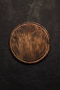 Round wooden cutting board on a black table. Top view of empty kitchen trendy rustic wooden tray Royalty Free Stock Photo