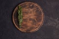 Round wooden cutting board on a black table. Top view of empty kitchen trendy rustic wooden tray Royalty Free Stock Photo