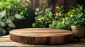 Round wooden cutting board on table with green plants in background Royalty Free Stock Photo