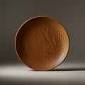 Round wooden plate with a smooth finish and prominent wood grain patterns. The pla Royalty Free Stock Photo