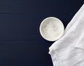 Round wooden plate and white linen towel on blue wooden background Royalty Free Stock Photo