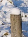 Round wooden posts of a wooden fence covered with snow hoods Royalty Free Stock Photo