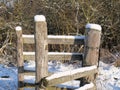 Round wooden posts of a wooden fence covered with snow hoods at a cattle pasture Royalty Free Stock Photo