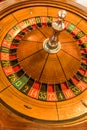 Round, wooden roulette wheel with numbers around the wheel