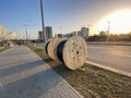 Round wooden skeins with electricity cable. the cable is wound on a large, wooden spool. construction site, cable laying