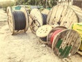 Round wooden skeins with electricity cable. the cable is wound on a large, wooden spool. construction site, cable laying Royalty Free Stock Photo