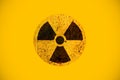 Round yellow and black radioactive hazard ionizing radiation nuclear danger warning symbol on rusty metal grungy texture