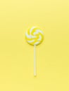 Round yellow lollipop on a yellow background. The concept of sweets Royalty Free Stock Photo