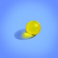 Round yellow pill on blue background. Close up pharmacy health care concept. Organic liquid nutrition, oil