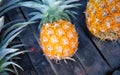 Round yellow pineapple on rustic wooden stall. Ripe pineapple bunch for sale on tropical farm market Royalty Free Stock Photo