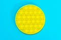 Round yellow popit on a blue background. Antistress toy trend of 2021