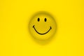 Round and yellow smiling face on yellow background surface