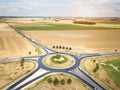 Roundabout drone aerial view with vehicles circling around the traffic circle lane, France country side rural road transportation