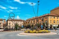 Roundabout with flowers and town square with modern sculpture in Alba, Italy