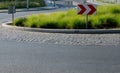 Roundabout of gray granite cubes closer to the center. beveled concrete curbs with flowers and grass in the middle of the circle.