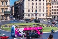 Roundabout at Piazza Venezia in Rome. Traffic junction in front of the monument Vittorio Emanuele II. Colourful hop-on hop-off bus