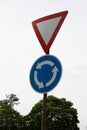 Roundabout roadsign with green tree and white skies Royalty Free Stock Photo