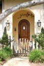 Rounded wooden door recessed in a porch provides an inviting entry way to a charming cottage in Carmel-by-the-Sea, CA. Royalty Free Stock Photo