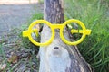 yellow glasses on a log with a knobby nose