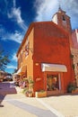 View over square of ancient village on colorful ochre natural stone house and medieval church bell tower against blue sky Royalty Free Stock Photo